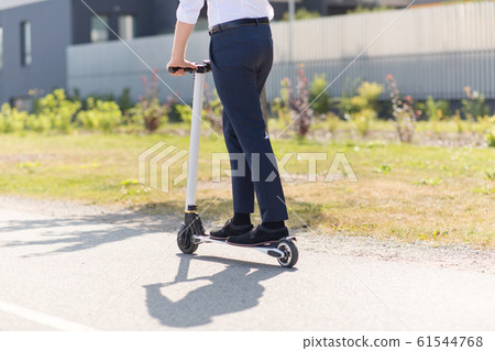 young businessman riding electric scooter outdoors young businessman riding electric scooter outdoors 61544768