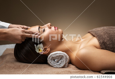 woman having face and head massage at spa woman having face and head massage at spa 61544908