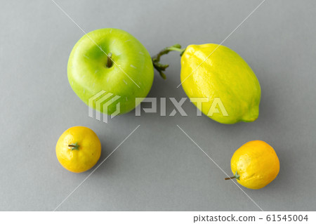 close up of green apple and lemons on grey close up of green apple and lemons on grey 61545004
