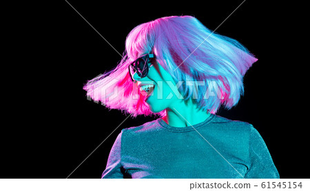 happy woman in pink wig and sunglasses dancing 61545154