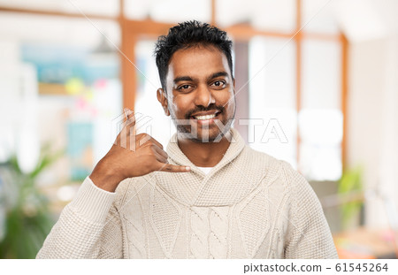 indian man in sweater making phone call gesture indian man in sweater making phone call gesture 61545264
