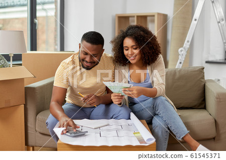couple with blueprint counting money at home couple with blueprint counting money at home 61545371