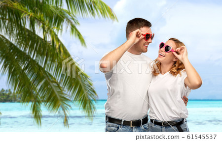 happy couple in white t-shirts and sunglasses happy couple in white t-shirts and sunglasses 61545537