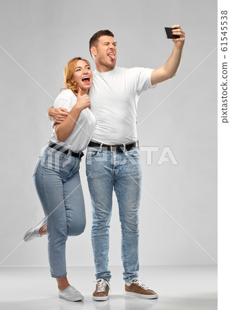 happy couple in white t-shirts taking selfie happy couple in white t-shirts taking selfie 61545538