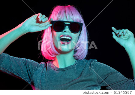 happy woman in pink wig and black sunglasses happy woman in pink wig and black sunglasses 61545597