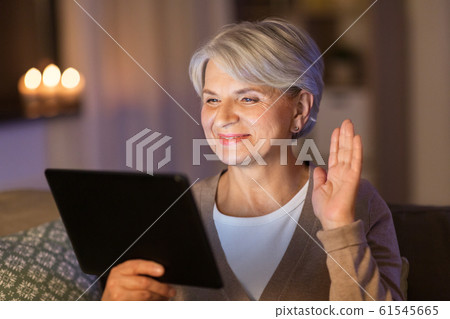 happy old woman with tablet pc having video call 61545665