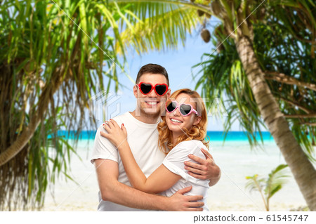 happy couple in white t-shirts and sunglasses 61545747