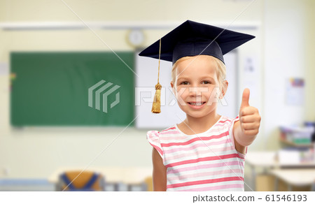 girl in mortarboard showing thumbs up at school 61546193
