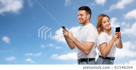 happy couple in white t-shirts with smartphones 61546204