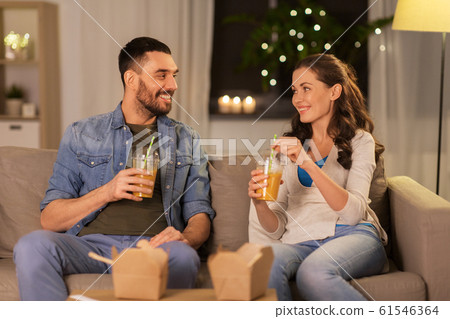 happy couple drinking takeaway juice at home 61546364