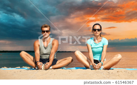 couple stretching legs on beach couple stretching legs on beach 61546367