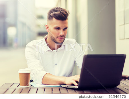 man with laptop and coffee at city cafe man with laptop and coffee at city cafe 61546370