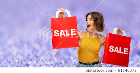 happy young woman with shopping bags on sale 61546372