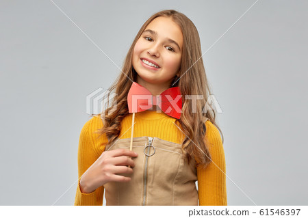 happy teenage girl with red bowtie party accessory happy teenage girl with red bowtie party accessory 61546397