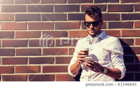 man with smartphone and coffee cup on city street 61546643