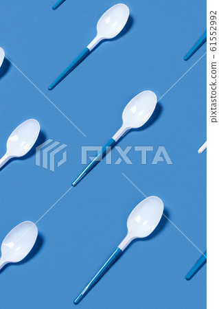 Pattern of white spoons on blue background. 61552992