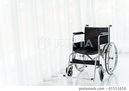 Empty wheelchair in hospital ward 61553858