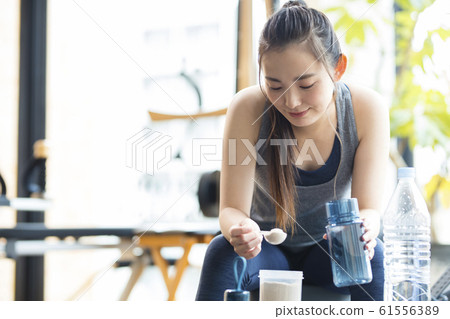 Woman making protein drink 61556389