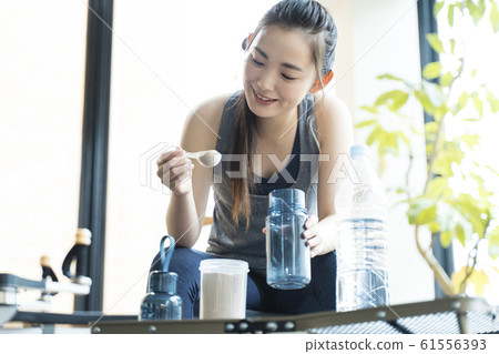 Woman making protein drink 61556393