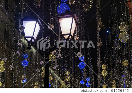 Metal lantern on background of neon garlands, city decor. Christmas, fest backdrop. Concept holidays, festive occasions Metal lantern on background of neon garlands, city decor. Christmas, fest backdrop. Concept holidays, festive occasions 61556545