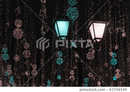 Metal lantern on background of shiny neon garlands. Festive occasions concept, holiday, Christmas, New Year backdrop Metal lantern on background of shiny neon garlands. Festive occasions concept, holiday, Christmas, New Year backdrop 61556549