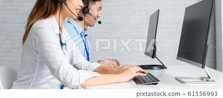 Call center agents using computers working in office 61556993