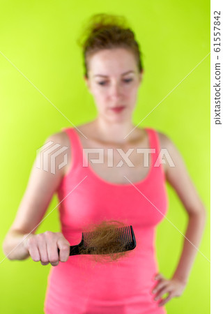 White woman showing comb full of hair. Hairloss concept 61557842