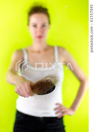 Blurred caucasian girl with hairbrush full of hair 61557845
