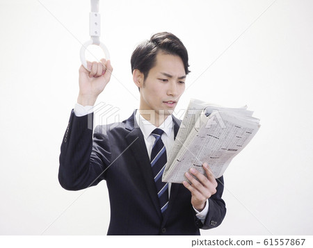 Businessman holding newspaper and looking at newspaper 61557867