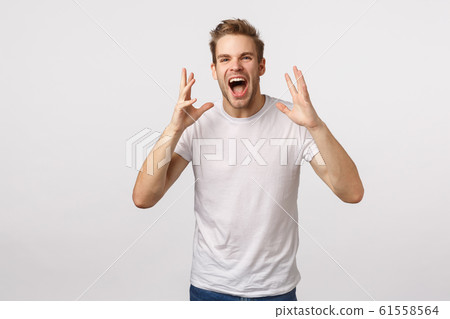 Expressive charismatic happy young man sharing his happiness with world, shaking hands feeling luck and upbeat, shouting, calling someone, yelling to call name friend, white background Expressive charismatic happy young man sharing his happiness with world, shaking hands feeling luck and upbeat, shouting, calling someone, yelling to call name friend, white background 61558564
