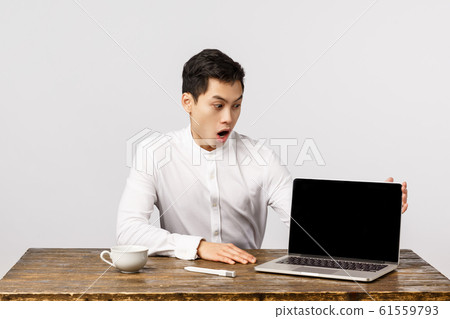 Impressed, shocked and astonished young chinese man in office, manager sitting table looking laptop screen, showing something incredible at display, say wow, drop jaw and gasping amazed Impressed, shocked and astonished young chinese man in office, manager sitting table looking laptop screen, showing something incredible at display, say wow, drop jaw and gasping amazed 61559793