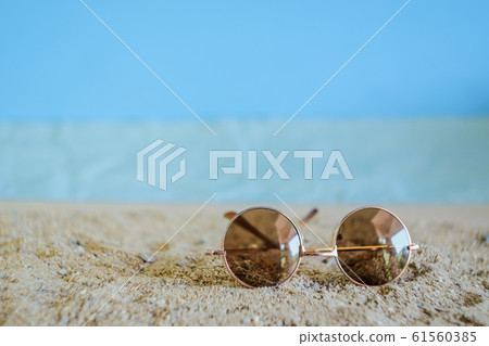 Sunglasses eyeware drop on tropical sand beach. Sunglasses eyeware drop on tropical sand beach. 61560385
