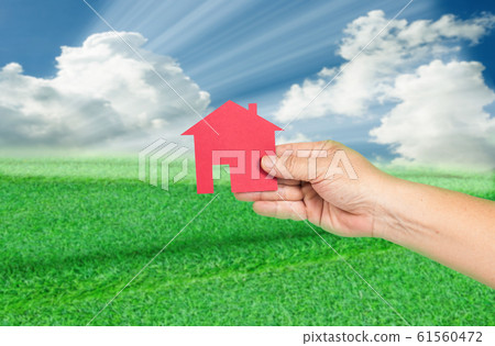 Red house in hand with landscapes background. Real 61560472