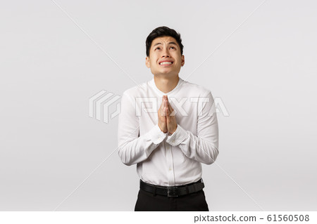 Worried and inescure young asian guy in forma outfit, clasp hands together in pray near chest, look up sky, begging god, supplicating, put effort to hope everything be okay, ask please Worried and inescure young asian guy in forma outfit, clasp hands together in pray near chest, look up sky, begging god, supplicating, put effort to hope everything be okay, ask please 61560508