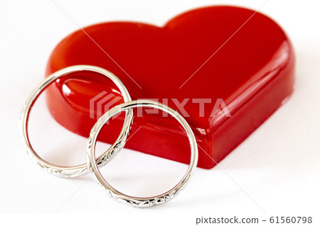 Pair of wedding rings and red heart 61560798