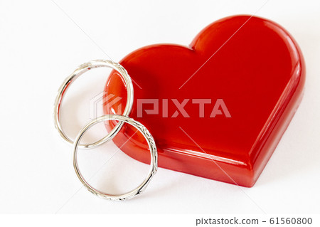 Pair of wedding rings and red heart Pair of wedding rings and red heart 61560800