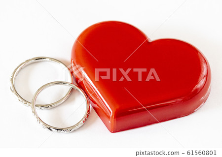 Pair of wedding rings and red heart 61560801