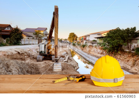 yellow construction safety helmet on wood 61560903