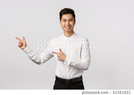 Young asian business man in a suit pointing with his finger on the white background. 61561831