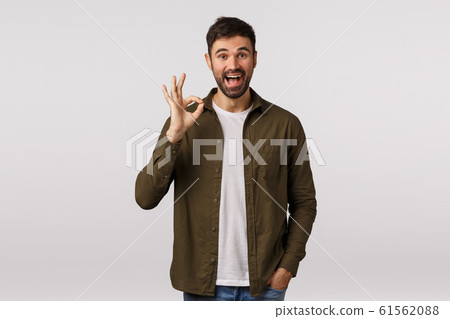 Proud and happy cute bearded man satisfied with friend making great choice, praise achievement, being satisfied and delighted, showing okay, not bad or good gesture and accept offer gladly, smiling 61562088