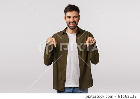 Must have, check out this promo. Cheerful attractive bearded guy advice corporate promo, pointing down at company banner, invite visit shopping site, smiling joyful, white background 61562132