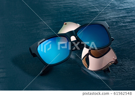 Two fashionable sunglasses on a blue background. 61562548