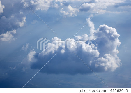 Sun beams is lighting through the big white clouds. Sun beams is lighting through the big white clouds. 61562643