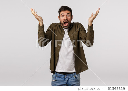 Shocked and embarrassed, bearded man panicking, raise hands up sideways puzzled and confused, feeling frustrated and speechless, gasping stare camera troubled, faced strange situation Shocked and embarrassed, bearded man panicking, raise hands up sideways puzzled and confused, feeling frustrated and speechless, gasping stare camera troubled, faced strange situation 61562819