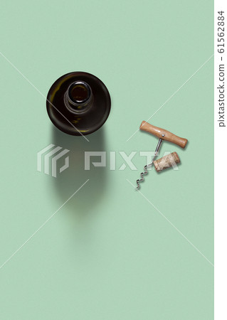 Opened bottle of wine with corkscrew and cork. 61562884
