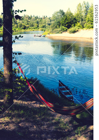 Bright hammock and boat on the blue river Bright hammock and boat on the blue river 61562953