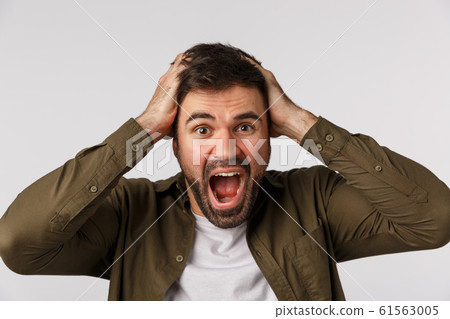 Man in panic and fear losing mind, feeling upset and alarmed. Troubled puzzled and depressed handsome bearded man grab head and shouting, cant deal with problems, standing white background Man in panic and fear losing mind, feeling upset and alarmed. Troubled puzzled and depressed handsome bearded man grab head and shouting, cant deal with problems, standing white background 61563005