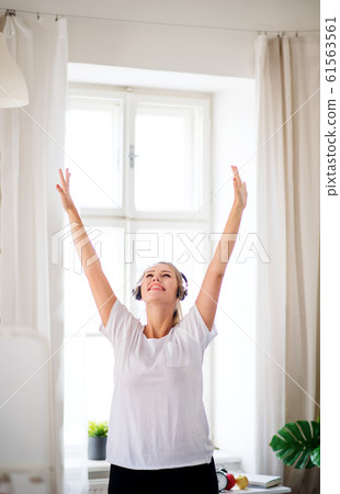 Young woman with headphones in bedroom indoors at home. Young woman with headphones in bedroom indoors at home. 61563561