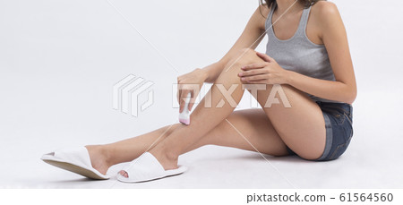 Woman trimming her leg with electric trimmer Woman trimming her leg with electric trimmer 61564560