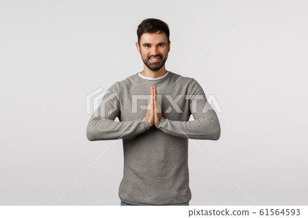 Cheerful and peaceful adult male yoga instructor teaching how release stress, bowing namaste gesture, hold hands pressed together over chest, praying, smiling delighted, asking help or thanking 61564593
